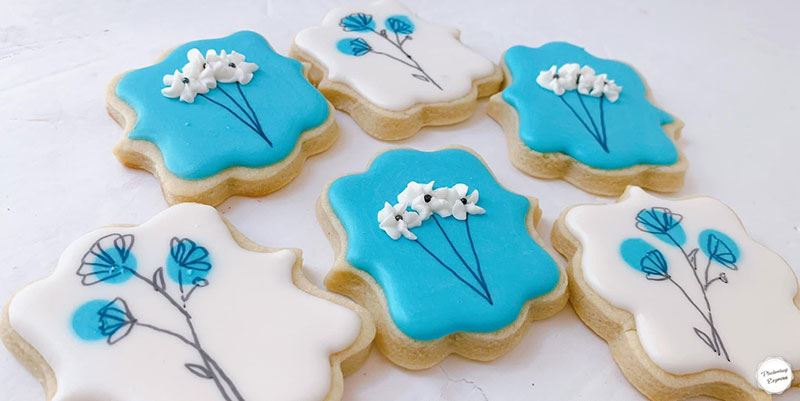 Cookies with blue and white flower patterns from Sugar Arts Bakehouse