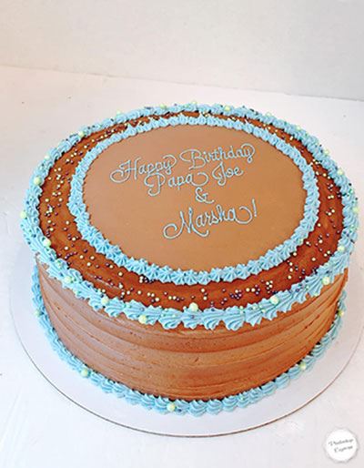 Chocolate frosted cake with blue icing decorations from Sugar Arts Bakehouse